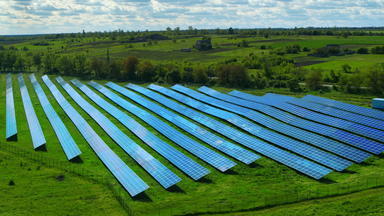 无人机拍摄蓝色的太阳面板行绿色场生态电<strong>发电机</strong>